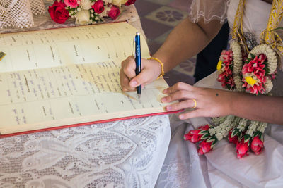 High angle view of woman reading book on table