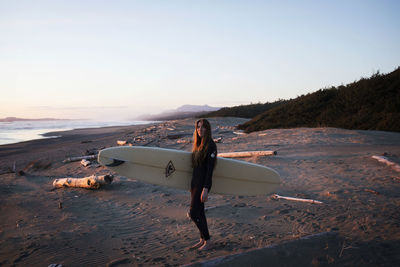 Surfer girl on the beach near tofino