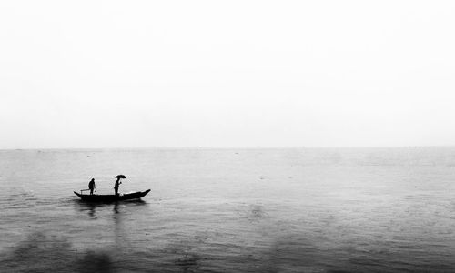 High angle view of fisherman in boat against sky