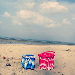 Lounge chairs on beach against sky