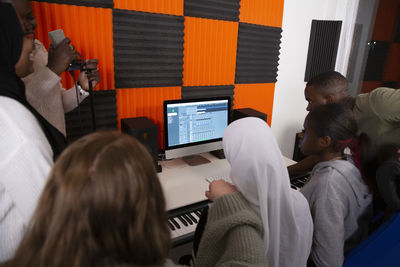 Rear view of artists working in recording studio