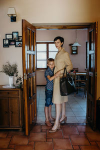 Full length of mother and daughter standing on floor