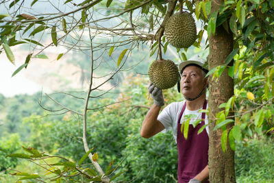 Full length of young man standing against plants