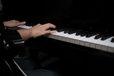 Cropped hand of man playing piano