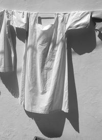 Clothes drying on clothesline against white wall