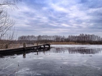 Scenic view of lake against cloudy sky