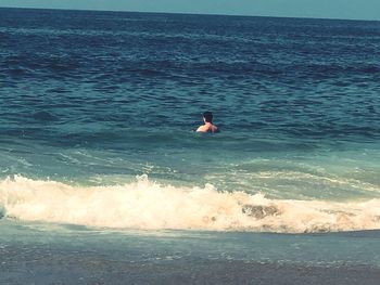 Man surfing in sea against sky