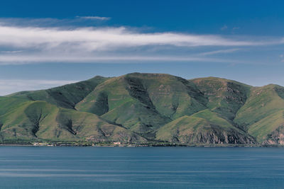 Scenic view of sea and mountains against sky