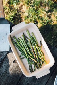 Bbq cookout backyard, grilled asparagus stalks in dish