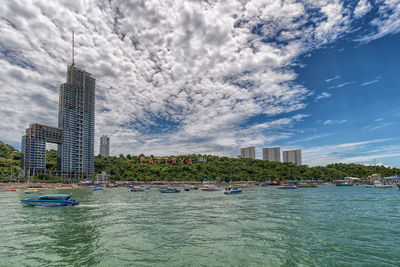 Buildings in city against cloudy sky