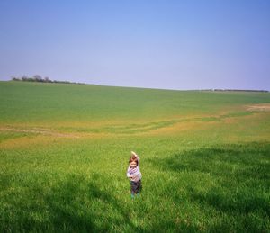 Child on field against clear sky