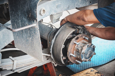 Cropped hand of man repairing vehicle in garage