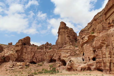 View of rock formations on landscape against cloudy sky