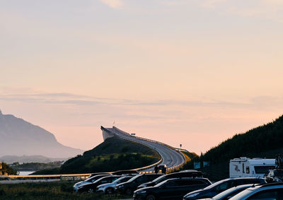 Cars on road against sky during sunset