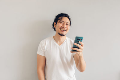 Smiling young man using mobile phone