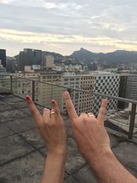 Low section of woman relaxing in city against sky