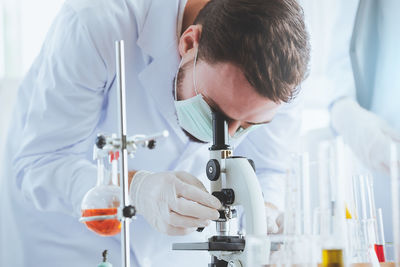 Scientist looking through microscope at laboratory