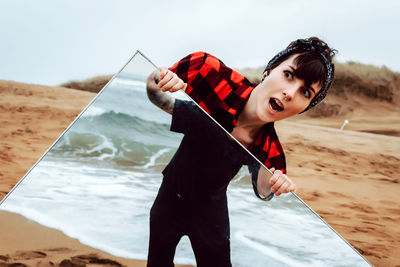 Portrait of young woman standing on beach