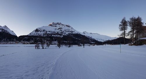 Scenic view of snow covered mountains against clear blue sky