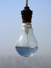 Close-up of light bulb against sky