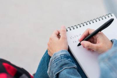 Close up of a young college student taking notes on campus