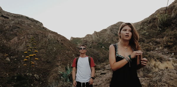 Friends standing against mountains