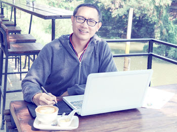 Portrait of smiling man sitting at table