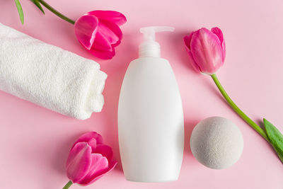 Spa skin care products on a pink background. natural cosmetics and red tulips. place for text.