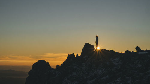 Silhouette rock formations against sky during sunset