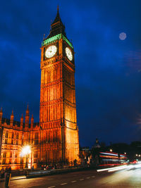 Illuminated clock tower against sky at night
