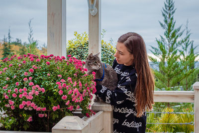 Beautiful woman standing by flowering plants