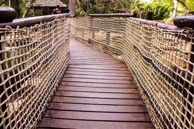 Rear view of woman walking on footbridge