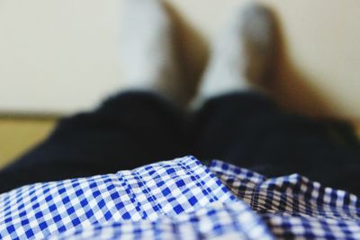 Low section of woman sitting on bed