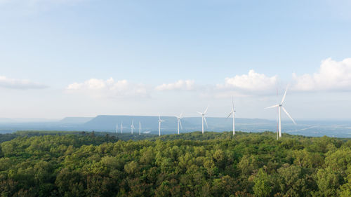 Wind turbines on land against sky