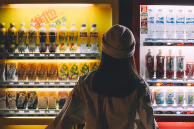 Rear view of woman standing at market stall