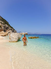 Shirtless man standing at beach