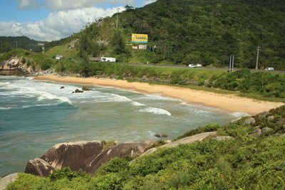 Scenic view of beach against green mountain