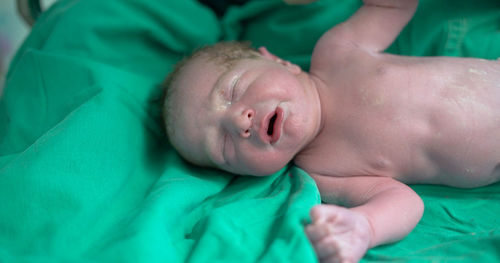 Close-up of baby boy lying on bed