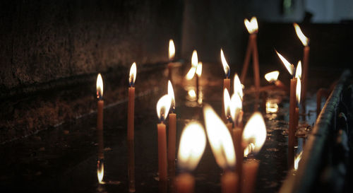 Close-up of lit candles in temple