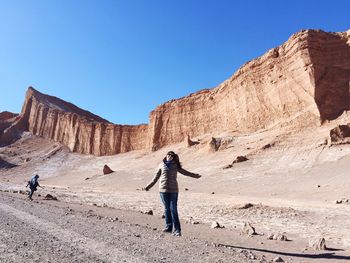 Woman standing at valle de la luna in atacama desert
