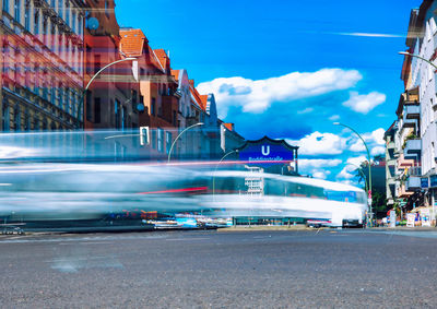 Blurred motion of vehicles on road in city against sky