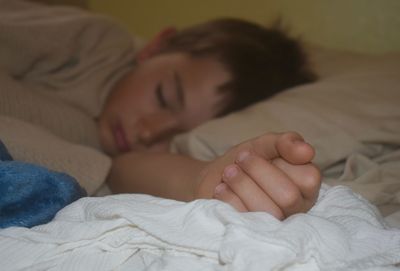 Close-up of baby sleeping on bed