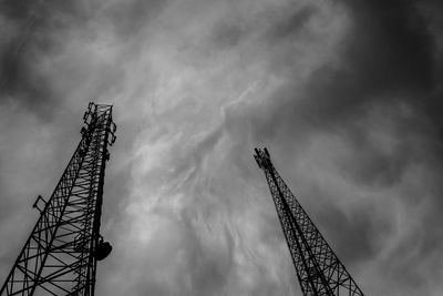 Low angle view of crane against cloudy sky