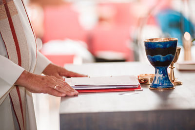 Close-up of hand holding tea cup on table