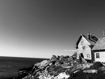 Scenic view of sea and buildings against clear sky