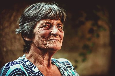 Close-up of senior woman looking away while standing outdoors