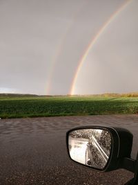 Scenic view of rainbow over road against sky