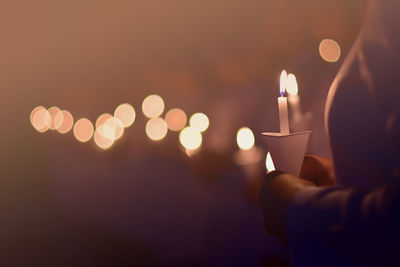 Midsection of woman holding burning candles