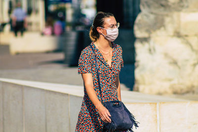 Woman looking away while standing outdoors