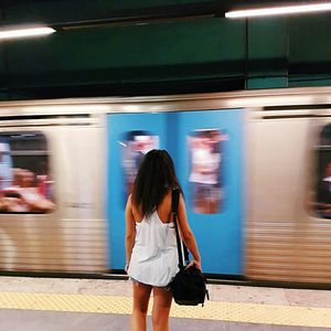 Rear view of woman on train at subway station